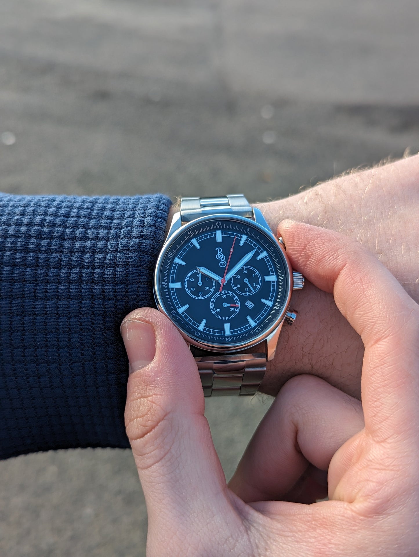 Adjusting time on black sport chronograph watch, lifestyle wrist shot
