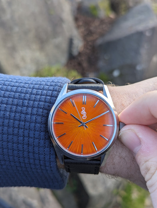 Orange Sunburst Watch on appleskin being set, gift for him