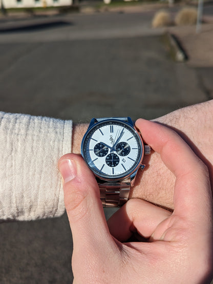 Adjusting time on white and black chronograph wristwatch lifestyle shot