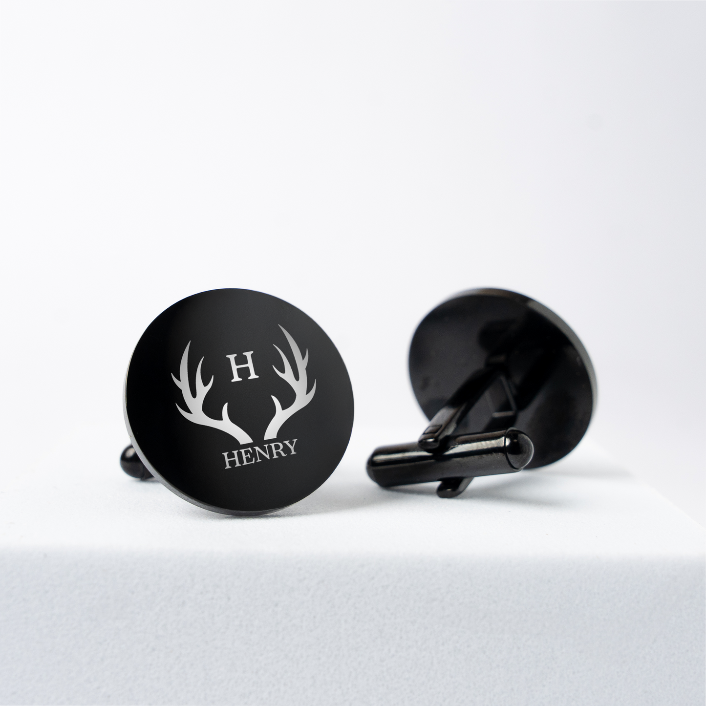 Black round cufflinks close-up showing laser engraving for the groom