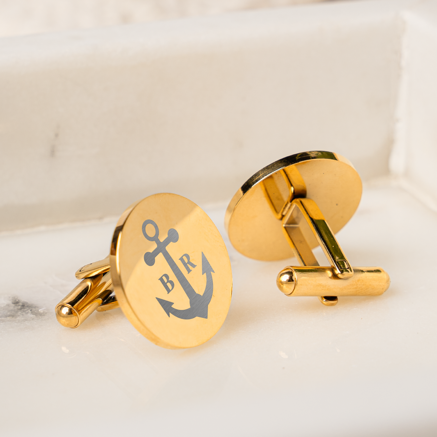 Gold circle cufflinks close-up showing custom monogram for the groom