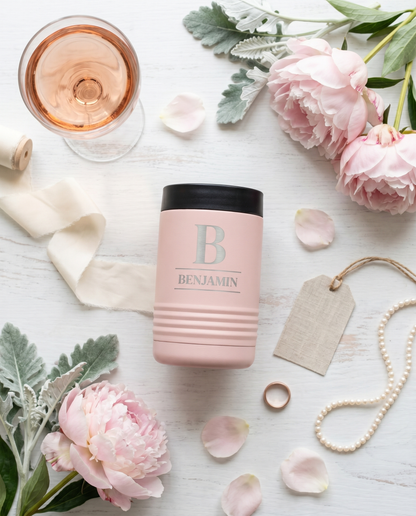 Personalized blush pink stainless steel insulated can cooler flat lay with rosé, peonies and pearls