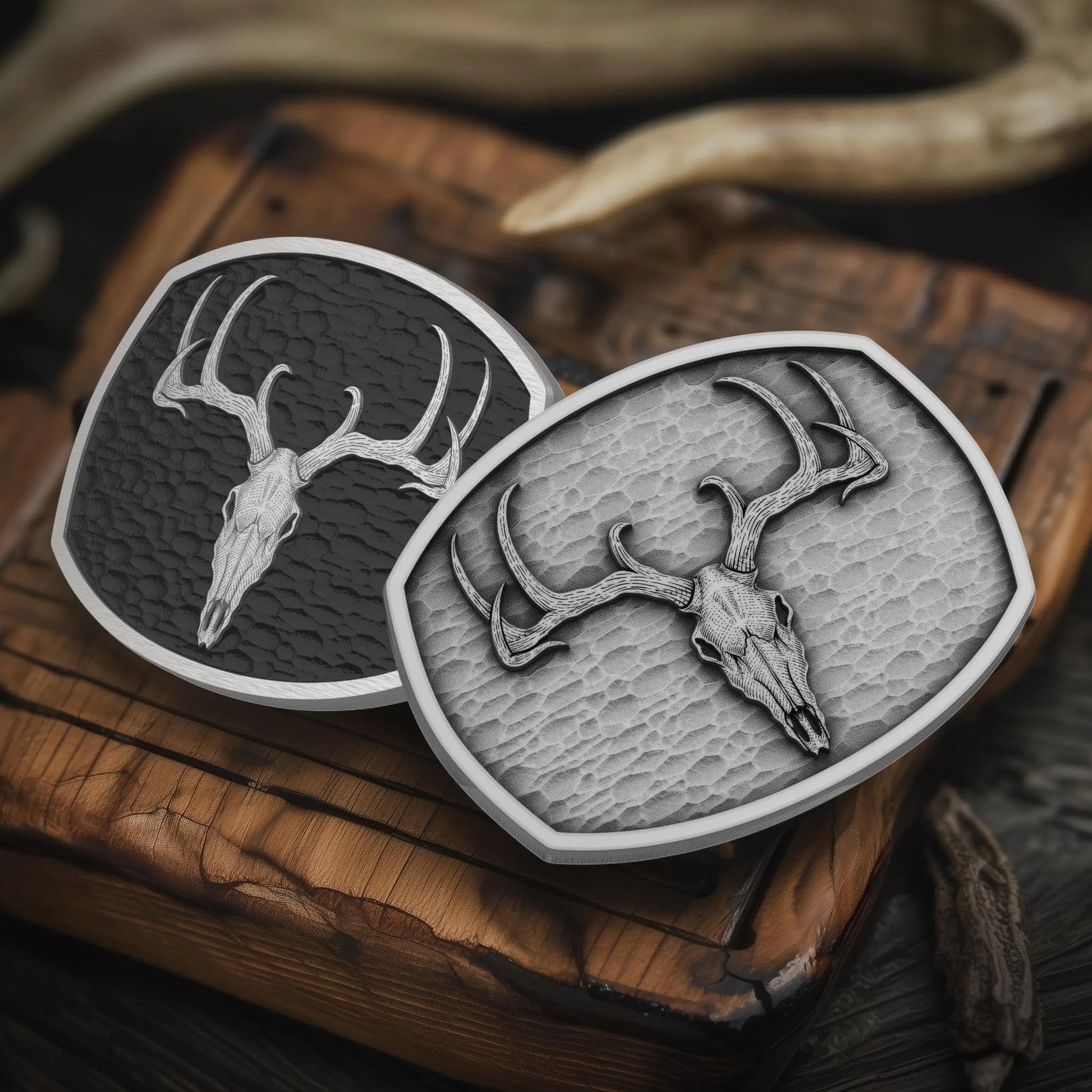 Deer skull belt buckles displayed on rustic wood