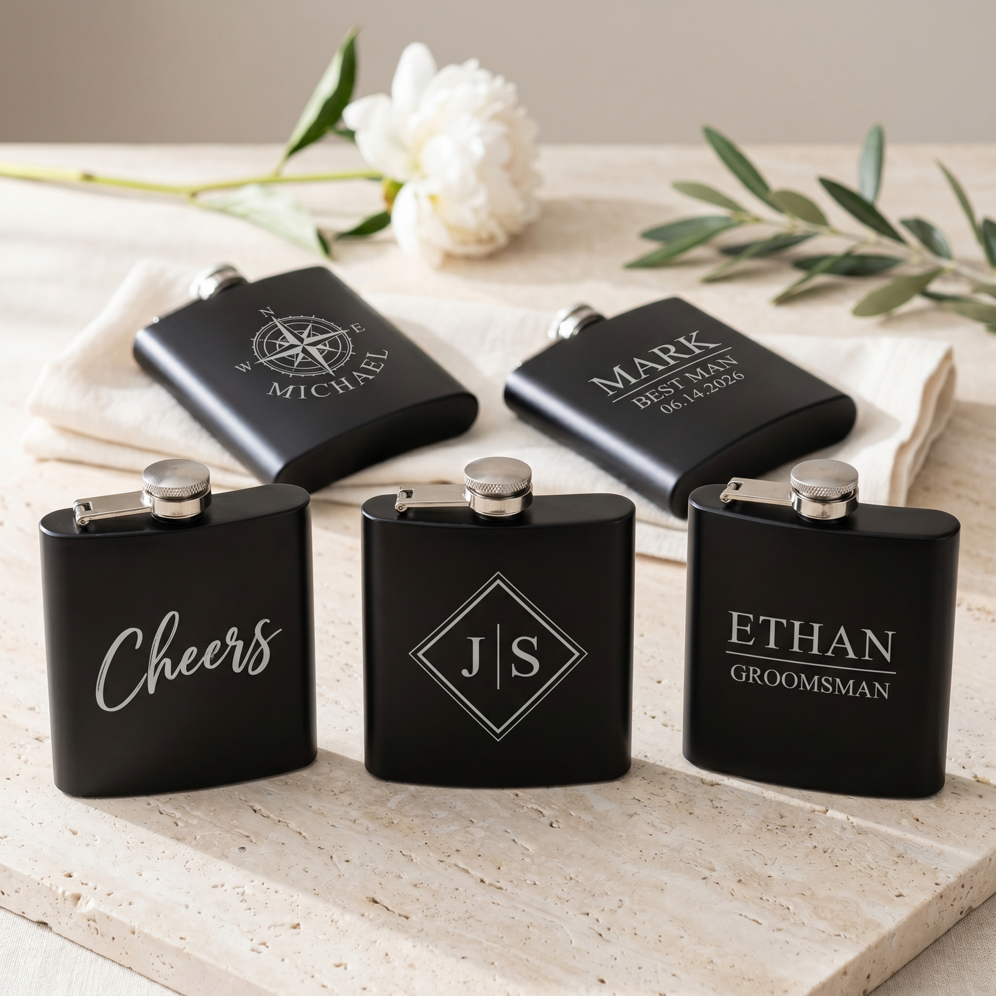 Engraved Black Powder Coated Flask - styled lineup of 5 flasks showing range of personalized engraving designs