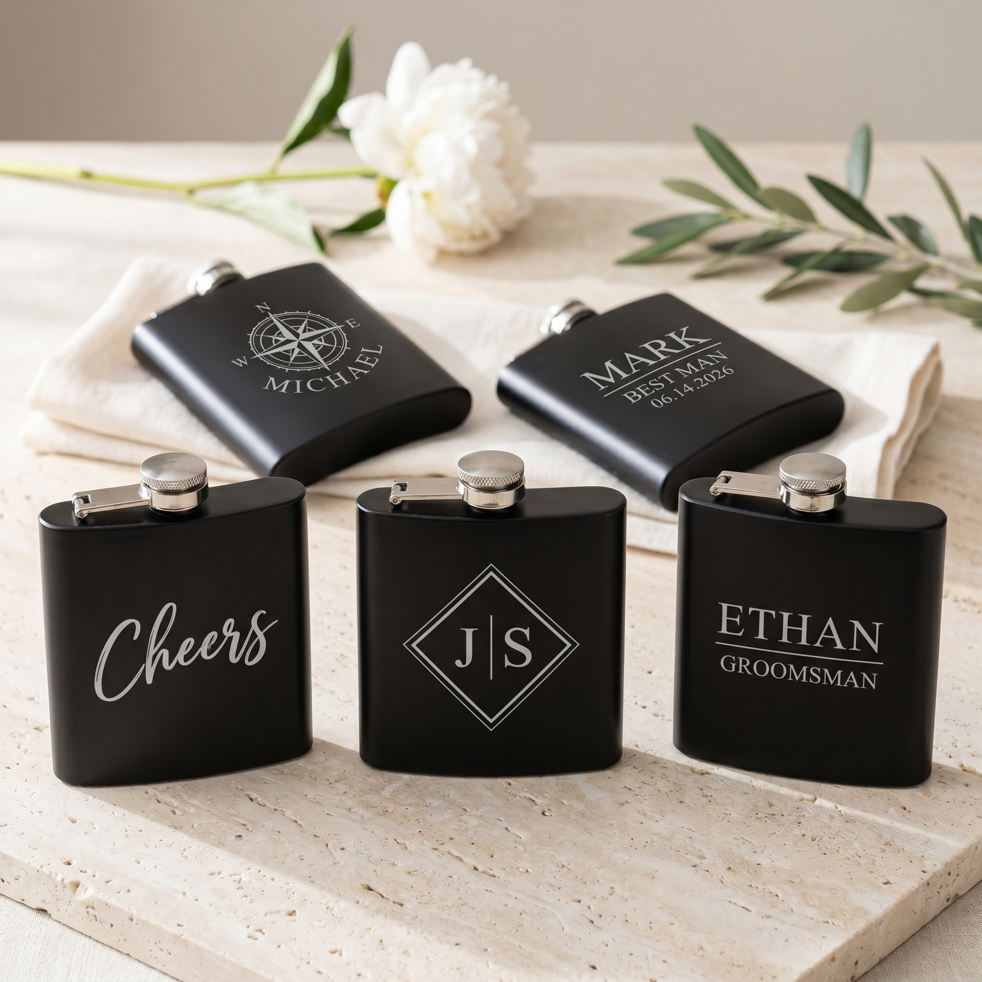 Engraved Black Powder Coated Flask - styled lineup of 5 flasks showing range of personalized engraving designs