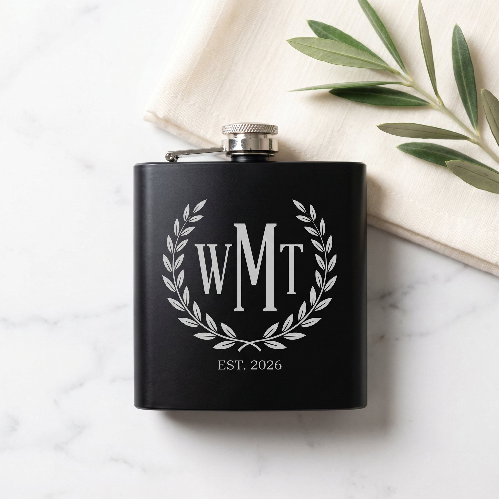 Engraved Black Powder Coated Flask - WMT three-letter monogram with laurel wreath, overhead flat lay