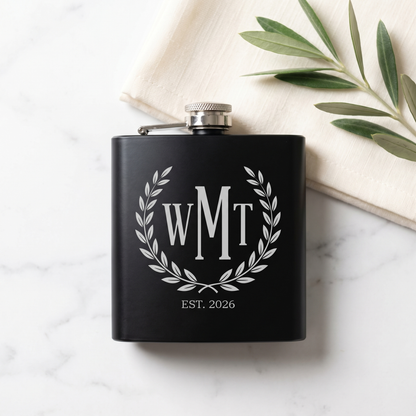 Engraved Black Powder Coated Flask - WMT three-letter monogram with laurel wreath, overhead flat lay