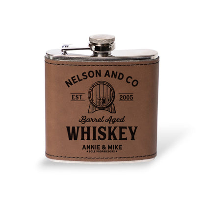 Dark brown leather flask engraved with the Nelson and Co barrel aged whiskey label, best man gift