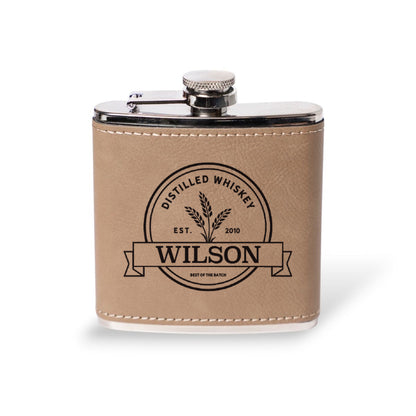 Light brown leather flask engraved with the Wilson distilled whiskey label, personalized groomsmen gift