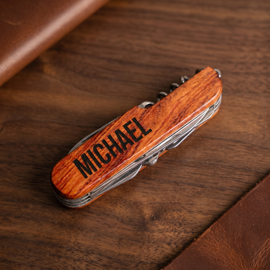 Personalized wood-handled multitool pocket knife with engraved name on walnut surface