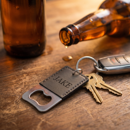 Dark brown engraved keychain bottle opener on bar wood with keys and beer bottle — lifestyle
